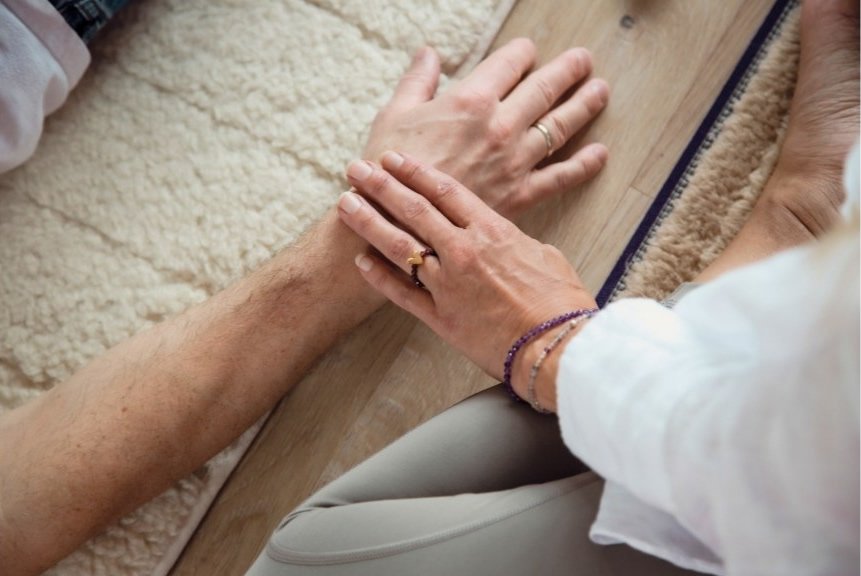 Energiearbeit mit Sat Nam Rasayan, Klient liegt auf Yogamatte, Isabella Kroll sitzt daneben